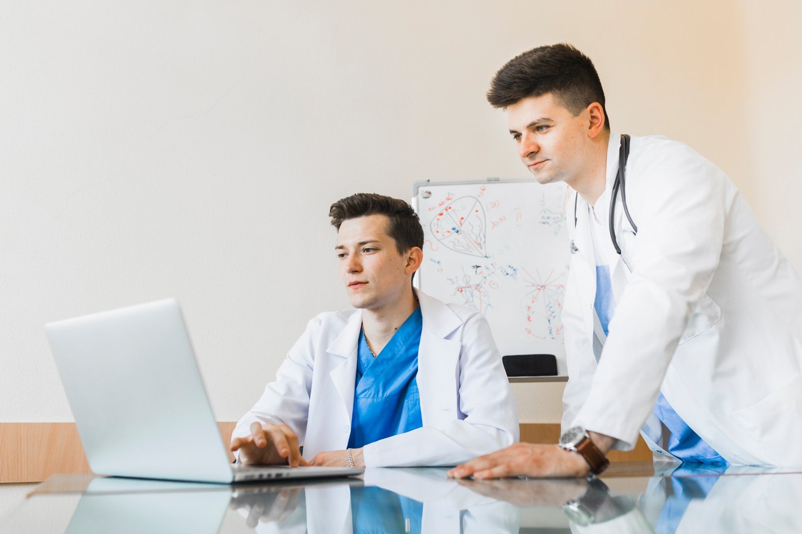 Two doctors reviewing information together on a laptop
