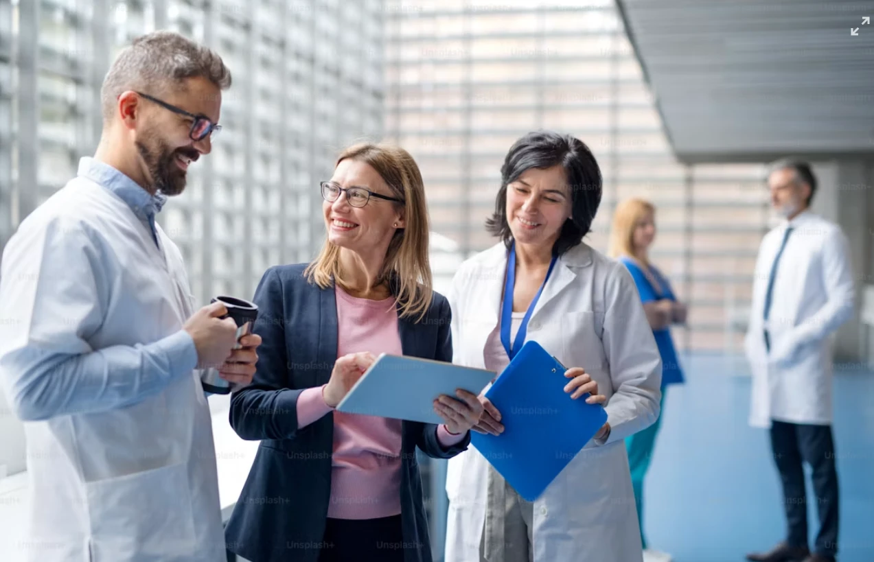 Consultant reviewing information on a tablet with doctors